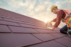 Roofer working in special protective work wear gloves, using air